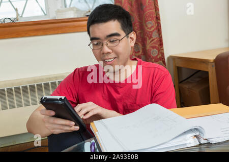Glücklich asiatischen Mann mit Autismus mit einem Telefon Stockfoto