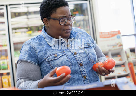 Frau mit bipolarer Störung Einkaufen für Tomaten Stockfoto
