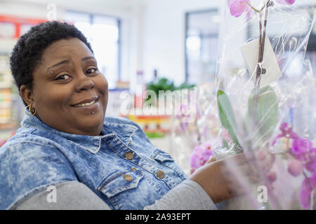 Porträt einer glücklichen Frau mit bipolarer Störung Shopping für Blumen Stockfoto