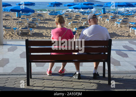 Paar auf einer Bank, am frühen Morgen, Playa Levante Strand, Benidorm, Alicante, Spanien Stockfoto