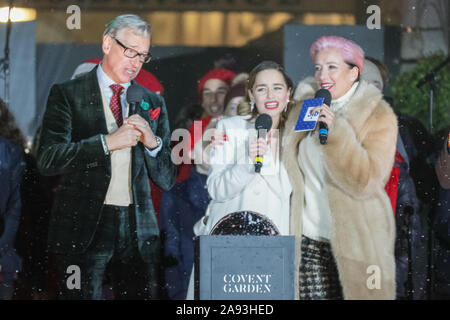 West End, London, Großbritannien, 12. November 2019. Die Stars der neuen Film "Last Christmas", Schauspielerinnen Emilia Clarke, (die auch im Spiel der Throne starred) und britischen Oscar ausgezeichnete Schauspielerin Emma Thompson, mit Regisseur Paul Feig (links). Zuschauer verfolgen die jährliche Bühnenperformance und Schalter auf der schönen Covent Garden Weihnachtsbaum und Leuchten im Londoner West End. Credit: Imageplotter/Alamy leben Nachrichten Stockfoto