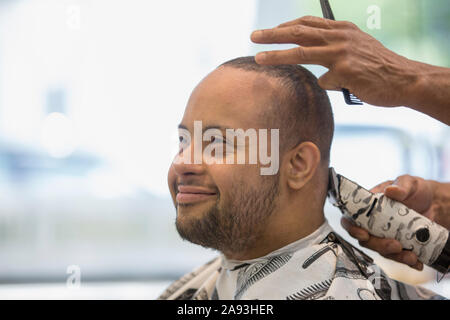 Mann mit Down-Syndrom bekommt einen Haarschnitt Stockfoto