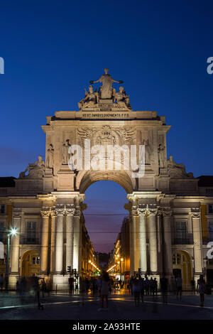 Das 18. Jahrhundert Arco da Rua Augusta (Triumphbogen Gateway) und Touristen an der Praca do Comercio Platz im Viertel Baixa in Lissabon in der Abenddämmerung. Stockfoto