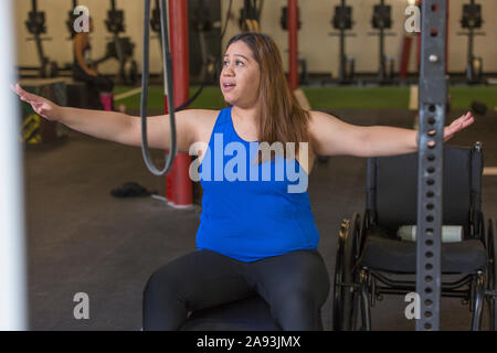 Frau mit Rückenmarksverletzung beim Training in einer Turnhalle Stockfoto