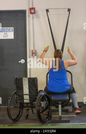 Frau mit Rückenmarksverletzung beim Training in einer Turnhalle Stockfoto