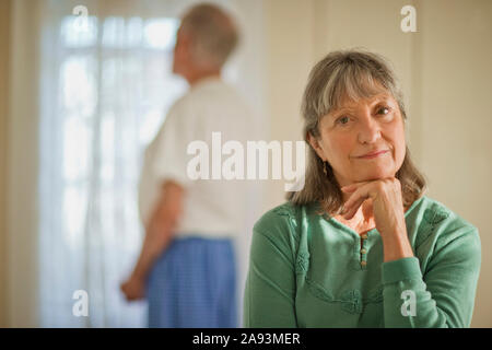 Porträt einer älteren Frau, die ihre Hand auf sie ruhte Kinn und deprimiert Stockfoto