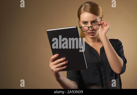 Hübsches Mädchen, Gläser und Tablet mit Verworrenen Gesicht - frustrierte Gesicht an Tablet - Studio shot hübsches Mädchen mit Tablet Stockfoto