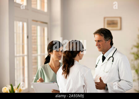 Zwei Ärzte und eine Krankenschwester, die ein Gespräch führt Stockfoto