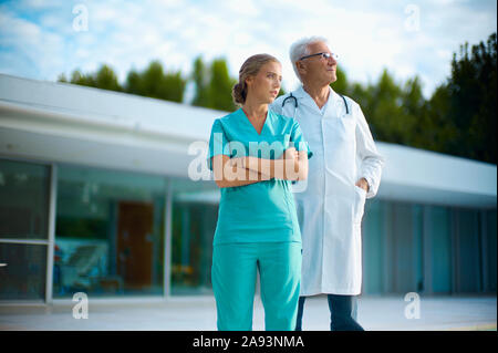 Porträt eines männlichen Senior Doctor stehend mit jungen weiblichen Krankenschwester Stockfoto