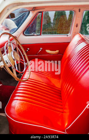 Kaliningrad, Russland - 22. August 2019. Vintage Wolga, Gaz21, Lenkrad mit einem Emblem im Innenraum, rot Leder. Stockfoto