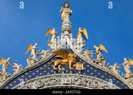 Eine Skulptur von St. Mark und der Löwe von Venedig, auf der Außenseite der Basilika von San Marco in Venedig, Italien. Stockfoto