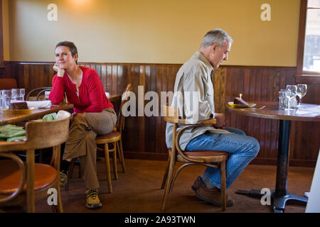 Unglückliche Paare an separaten Tabellen in einem Restaurant sitzen. Stockfoto