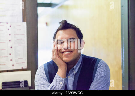 Mann aus dem Nahen Osten mit Down-Syndrom lächelt bei der Arbeit Stockfoto