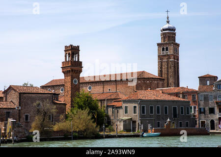 Ein Blick auf die historische Kirche von San Pietro Martire und die mittelalterliche Glockenturm von San Stefano Kirche auf der Insel Murano, die sich im befindet. Stockfoto