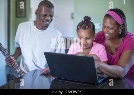 Familie arbeitet am Computer, Mann mit Williams-Syndrom Stockfoto