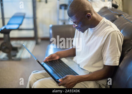 Mann mit Williams-Syndrom, der an einem Computer arbeitet Stockfoto