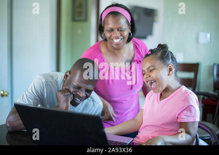 Familie arbeitet am Computer, Mann mit Williams-Syndrom Stockfoto