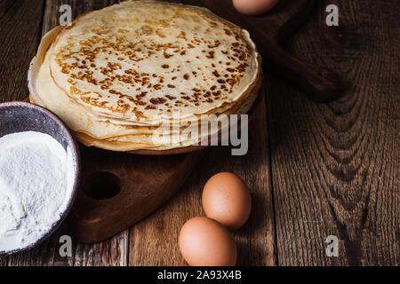 Dünne Pfannkuchen auf rustikalen Tisch, Zutaten, Blini, heimische Küche und Crepes Stockfoto