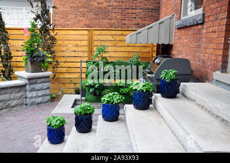 Moderne und traditionelle Elemente, diese schönen kleinen städtischen Garten verfügt über einen Sitz an der Wand, Terrasse, Luxus und Schuppen. Stockfoto