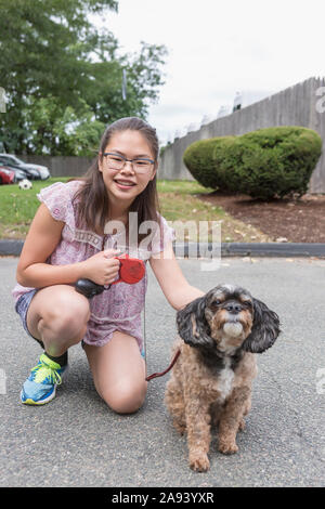 Teen Mädchen, die hat Lernen Behinderung spielen mit ihrem Hund Stockfoto