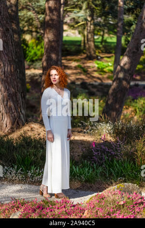 Porträt einer Frau mit roten Haaren zwischen Magnolien, Kamilia und Kirschblüten; Vancouver, British Columbia, Kanada Stockfoto