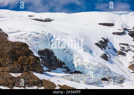 Gletscher Eis verschüttet über Klippen in der östlichen Alaska Range; Alaska, Vereinigte Staaten von Amerika Stockfoto