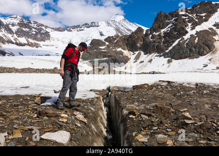 Ein Wanderer steht in einer Spalte am Castner Glacier in der Alaska Range mit Black Cap im Hintergrund; Alaska, Vereinigte Staaten von Amerika Stockfoto