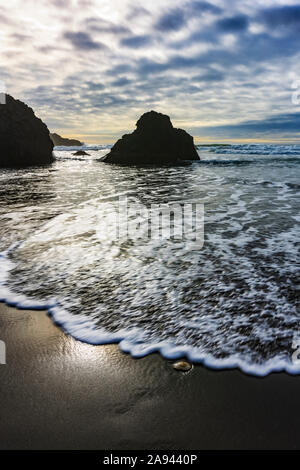 Silhouetten der Küste und Felsformationen entlang der Küste von Oregon bei Sonnenuntergang; Oregon, Vereinigte Staaten von Amerika Stockfoto