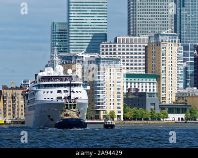 Das Kreuzfahrtschiff silver WInd' in London, gezogen von der Tugboat vitzer Brunel' auf der Themse zwischen Canary Wharf und die Tower Bridge (in der Nähe von Limehouse. Stockfoto