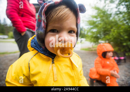 Portrait von jungen Mädchen in der regenkombi mit Schnuller. Stockfoto