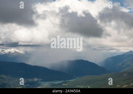 Ein regen Sturm ist in der Ferne sehen, wenn am Whistler Tal vom Berg an einem Frühlingstag. Stockfoto