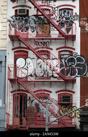 Fire Red Fire escape und Graffiti auf Mietshaus in New York Stockfoto