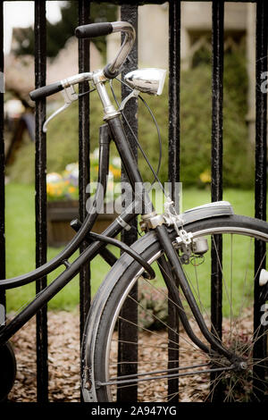 Gesperrt Fahrrad. Einen altmodischen Fahrrad mit retro Dynamo zu einigen Geländer durch ein Cambridge University College gesperrt. Stockfoto