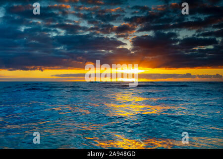 Heller, goldener Sonnenaufgang über dem Ozean; Kauai, Hawaii, Vereinigte Staaten von Amerika Stockfoto