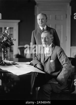 Us-Präsident Woodrow Wilson sitzt am Schreibtisch im Oval Office des Weißen Hauses mit seinem Privatsekretär Joseph Patrick Tumulty standen während Wilson der erste Term in Office, Washington, D.C., USA, Harris & Ewing, zwischen 1913 und 1916 Stockfoto