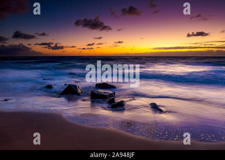 Heller, goldener Sonnenaufgang über Strand und Meer; Kauai, Hawaii, Vereinigte Staaten von Amerika Stockfoto