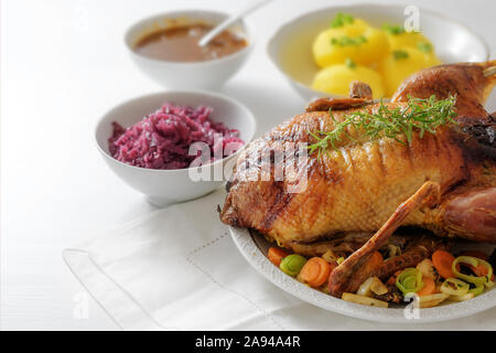 Gebratene ganze Ente mit Gemüse, Rotkohl, Kartoffeln und Soße, festliche Weihnachten Abendessen auf einem weißen Tisch, Kopie, mit ausgewählten Lwl schließen Stockfoto