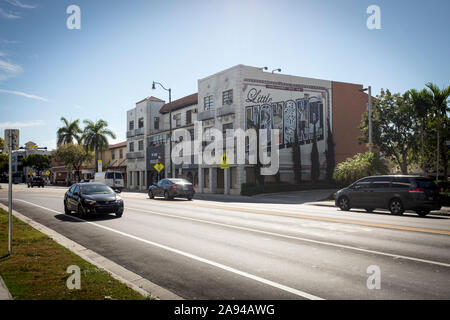 Autos fahren durch ein Gebäude mit Little Havana malte auf der Seite auf SW 8th Street, oder Calle Ocho, in Miami, Florida Stockfoto