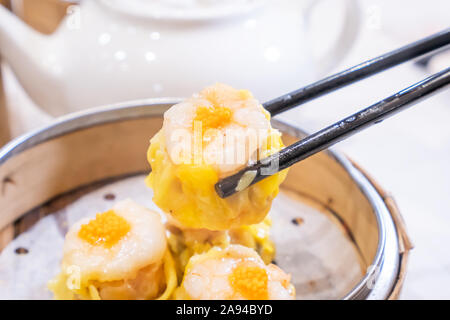 Siu Mai, ein Dim Sum yum cha, Schweinefleisch und Garnelen gedämpfte Teigtaschen auf Restaurant Haus weißen Hintergrund Tisch für Frühstück, Lifestyle, aus der Nähe. Stockfoto