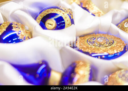 Weihnachtsbaum blauen Kugeln und mit goldenen Ornament und Glitzersteinchen auf einem weißen Seidentuch - closeup Soft Focus Hintergrund Stockfoto