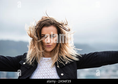 Porträt einer schönen jungen Frau mit windgeblasenem Haar; Wellington, Nordinsel, Neuseeland Stockfoto