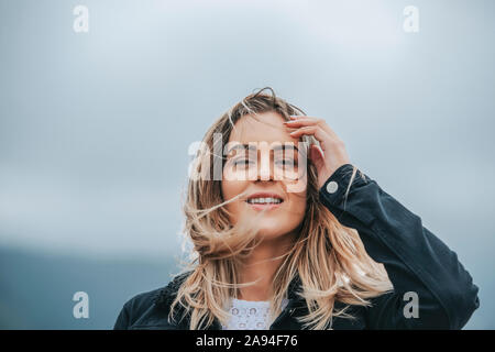 Porträt einer schönen jungen Frau mit windgeblasenem Haar; Wellington, Nordinsel, Neuseeland Stockfoto