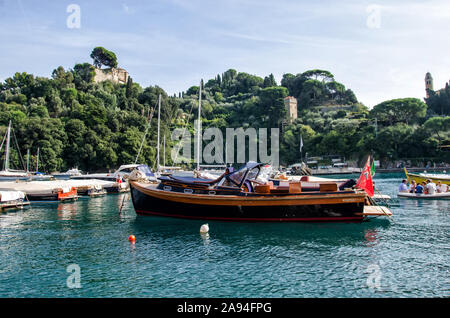 Italien, Portofino - 3. Oktober 2014: Boote auf dem Wasser in der malerischen Bucht von Portofino mit Blick auf die bunten Häuser Stockfoto