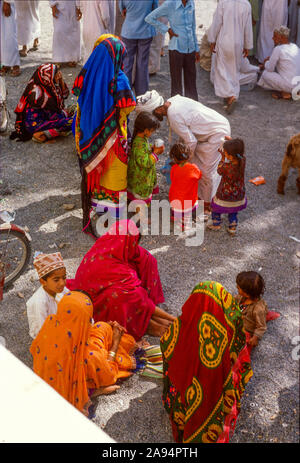 Lokale Omanis am Alten Souk in Nizwa, Oman, ca. 1984. Bunte Bekleidung ist ein Erbe der historischen Handelsbeziehungen zwischen dem Sultanat Oman und Zanzibar, Ostafrika Stockfoto