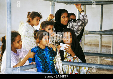 Omanische Mädchen versammeln sich ein Dorf Wassertank in der Musandam Halbinsel, ein OMANISCHE Enklave im östlichen Saudi-Arabien Stockfoto