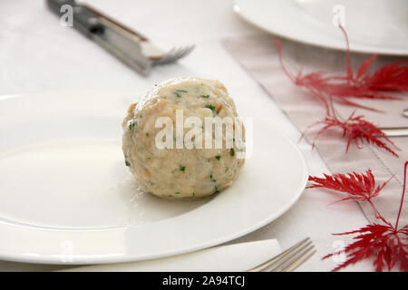 Ein großer Semmelknödel liegen auf weiße Platte auf elegant gedeckten Tisch Stockfoto