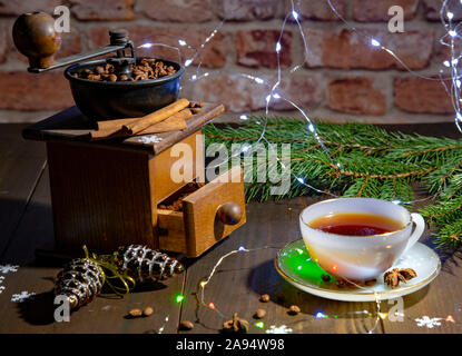Eine alte manuelle Kaffeemühle und eine Porzellan Schale gegen eine Mauer. Neue Jahr im Loft-Stil. Stockfoto