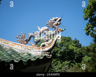 Nahaufnahme von einem Drachen Skulpturen verziert mit Mosaiken auf dem Dach eines alten Montagehalle in Hoi An, Vietnam Stockfoto