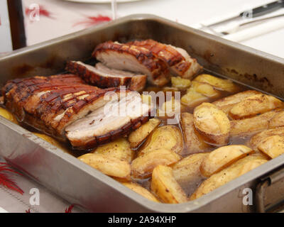 Hausgemachten Schweinebraten Bauch mit Bratkartoffeln geschnetzeltes ​​In Saft serviert in einem Bräter auf einem Tisch Stockfoto