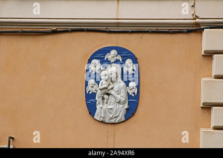 Detail eines alten Plakette an der Wand in den Straßen von Rom, Italien zeigt die Jungfrau Maria oder Madonna mit Kind und Engeln oder Putten um Sie herum Stockfoto